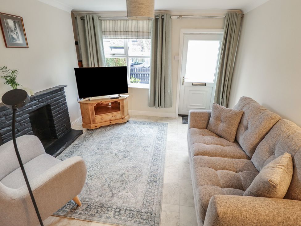 A living room with a sofa, television, and coffee table at Conisholme North Thoresby