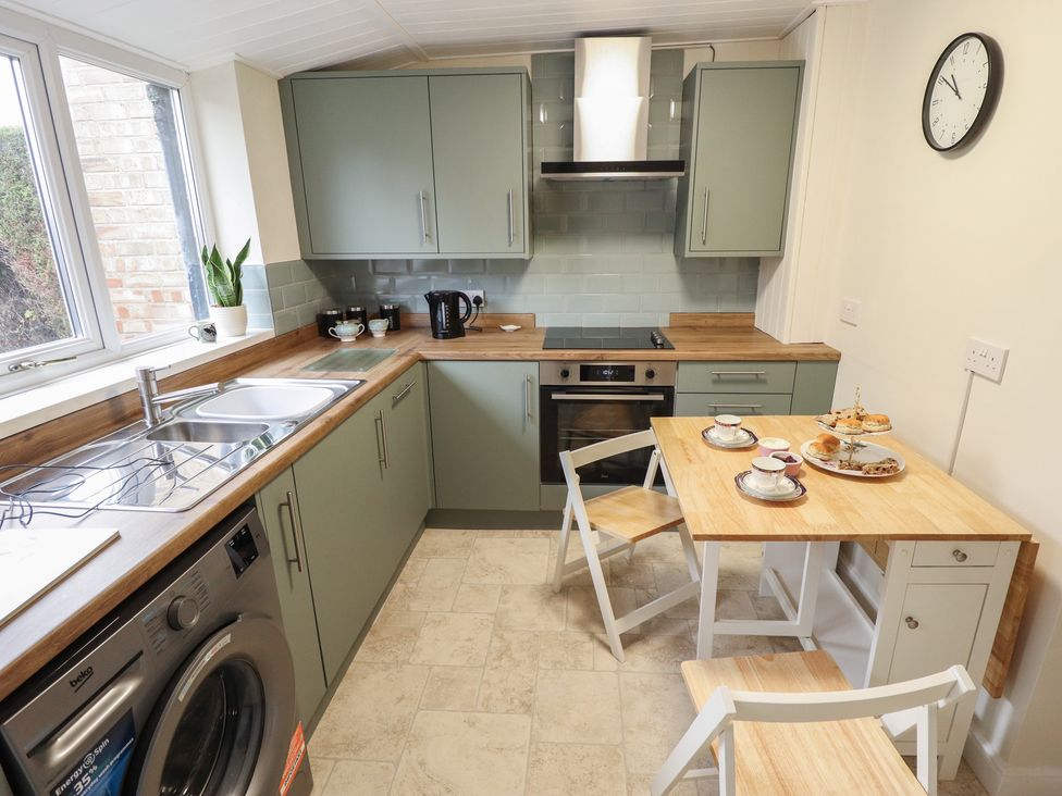 A kitchen with appliances and dining table at Conisholme in North Thoresby