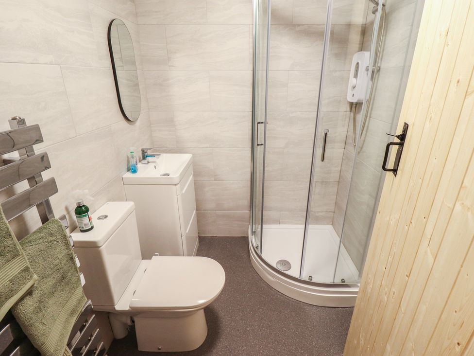 A bathroom with a shower, toilet, and sink at Conisholme in North Thoresby