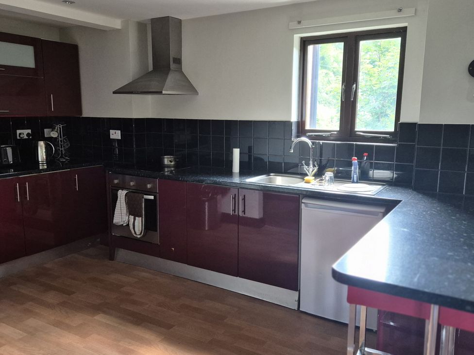 A kitchen with cabinets, stove, sink, and window at Flat 3, The Old Bakehouse, Telford