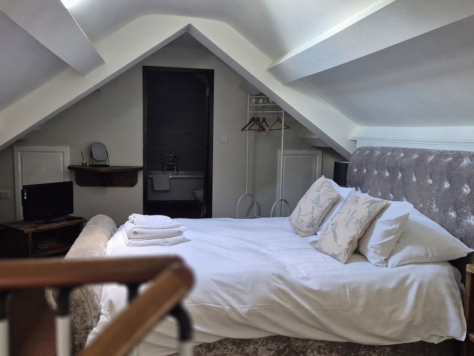 A bedroom with a bed and television at Flat 3, The Old Bakehouse in Telford