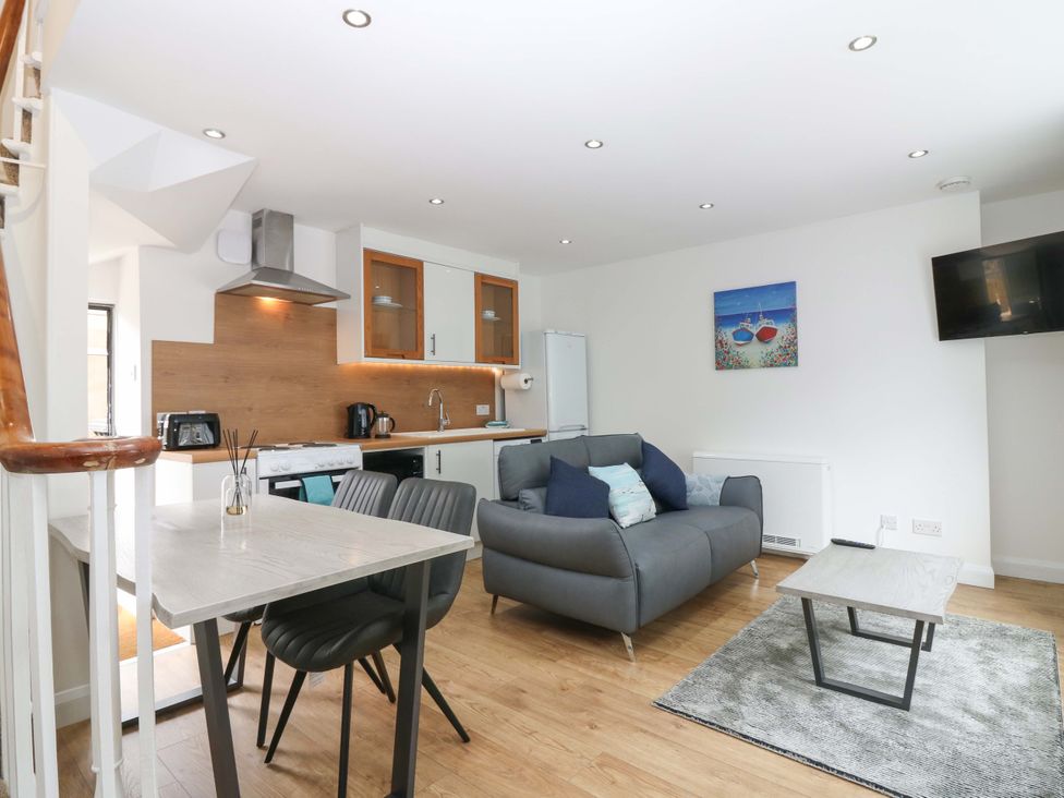 A living room with a sofa and dining table at 3 Caroline Place in Fraserburgh