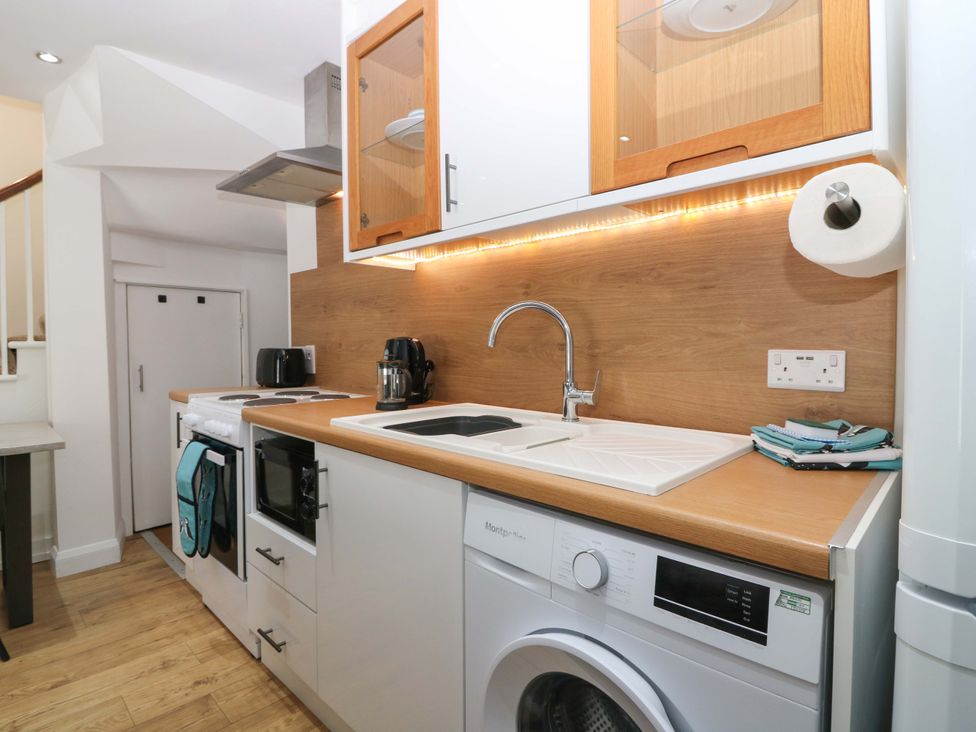 A kitchen featuring a sink, oven, and washing machine at 3 Caroline Place, Fraserburgh