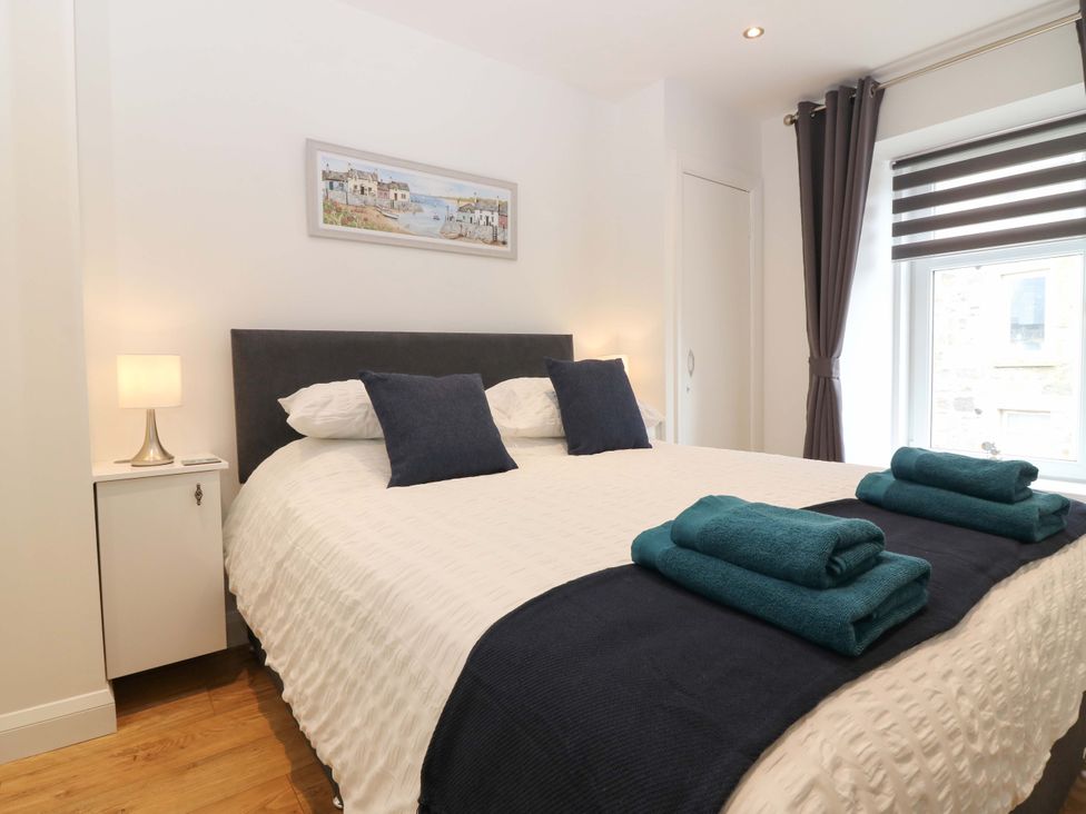 A bedroom with a bed and nightstand at 3 Caroline Place Fraserburgh