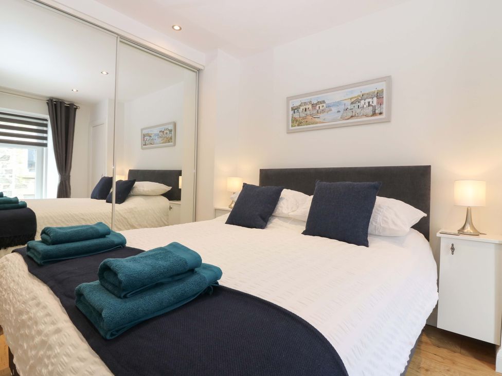 A bedroom with a mirrored wardrobe and bedside tables at 3 Caroline Place Fraserburgh