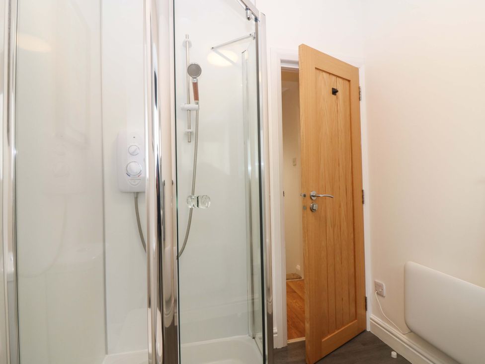 A bathroom with a shower and door at 3 Caroline Place in Fraserburgh