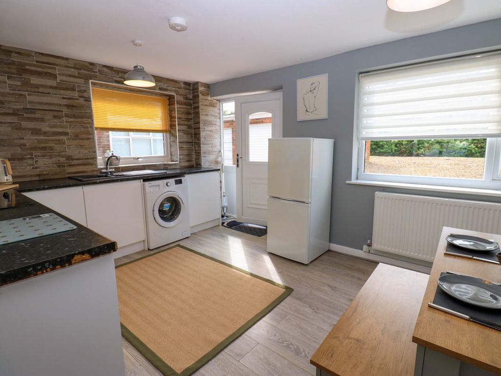 A kitchen with a refrigerator and washing machine at 8 Shearwater Way in Blyth