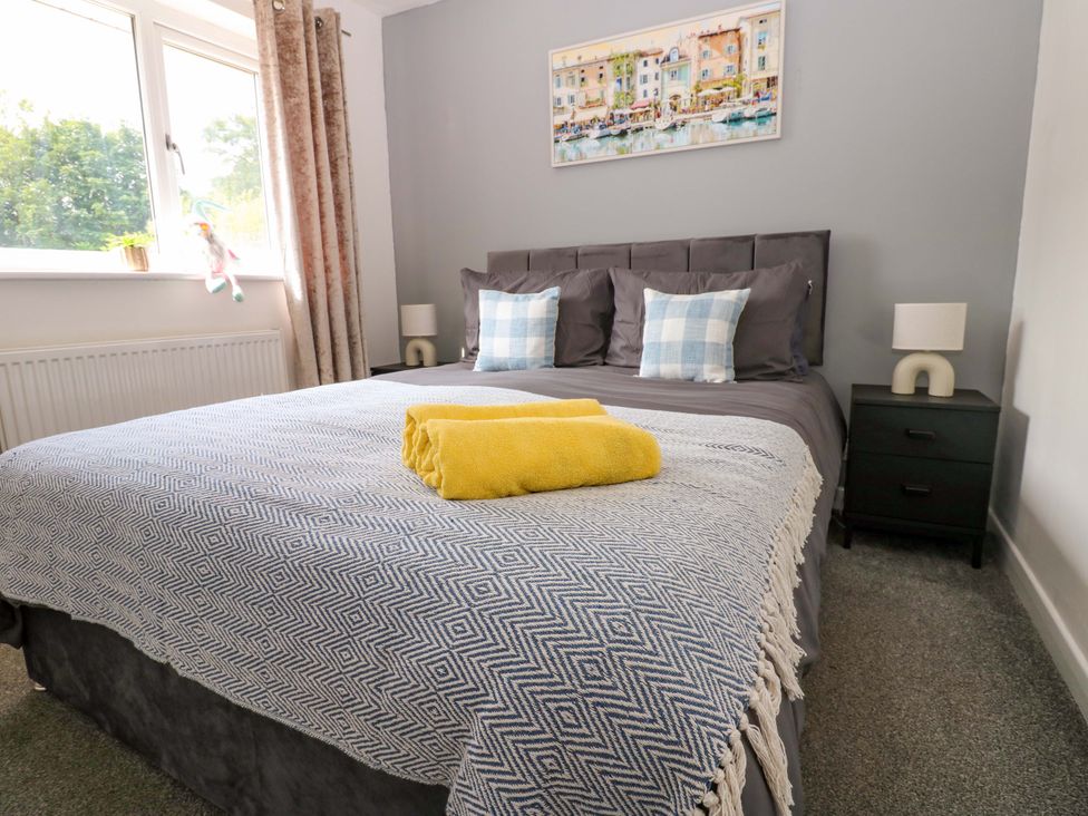 A bedroom with a bed and nightstand at 8 Shearwater Way in Blyth
