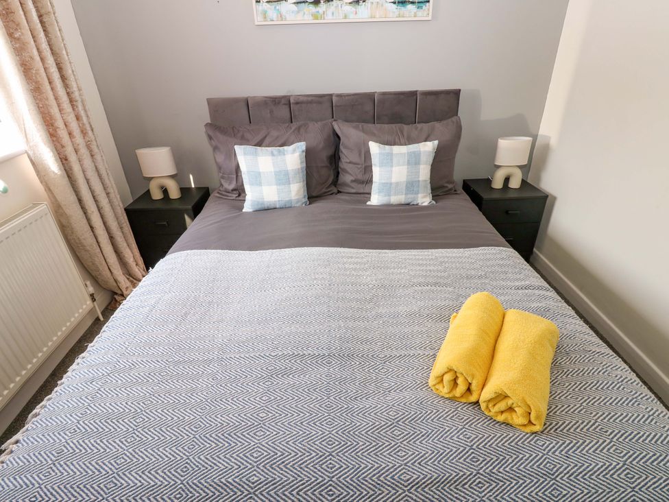 A bedroom featuring a bed with pillows and towels at 8 Shearwater Way Blyth