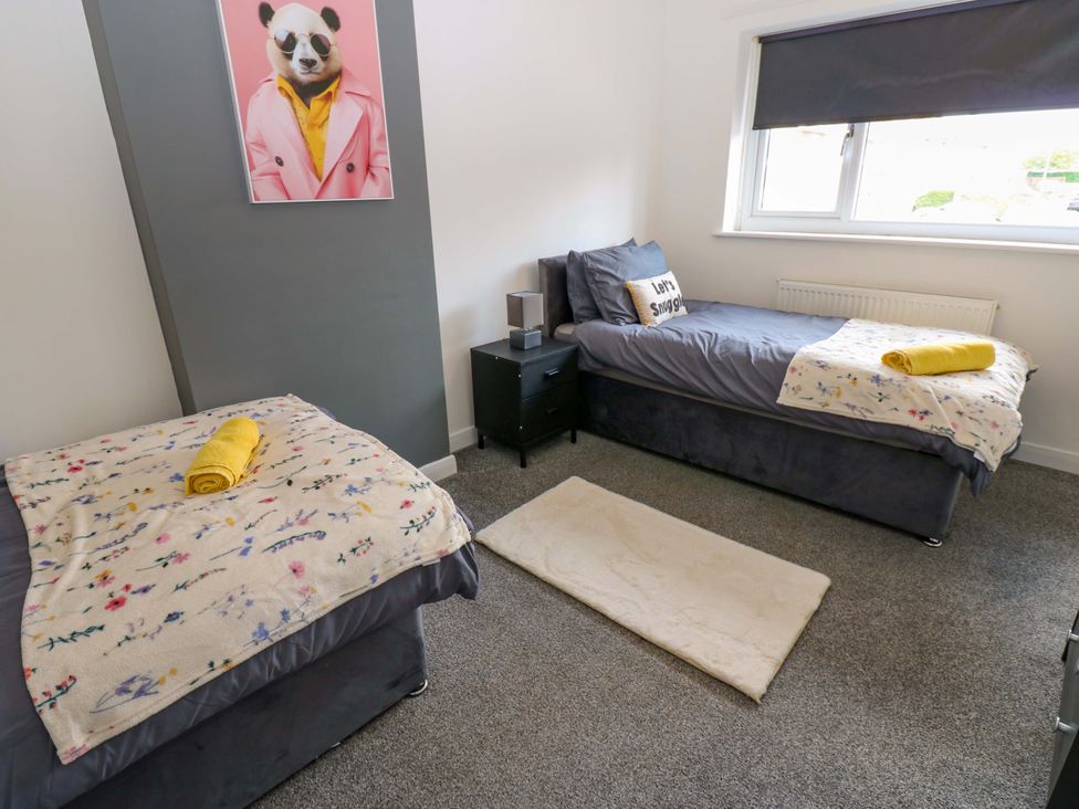 A bedroom with two beds and a nightstand at 8 Shearwater Way Blyth