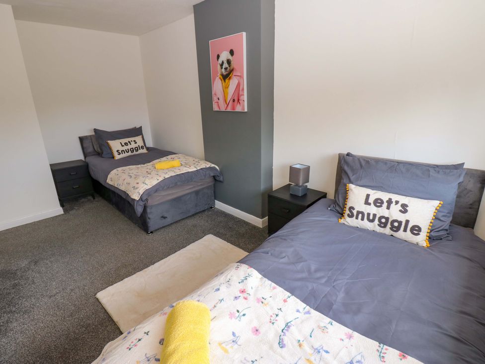 A bedroom with two single beds and decorative pillows at 8 Shearwater Way in Blyth