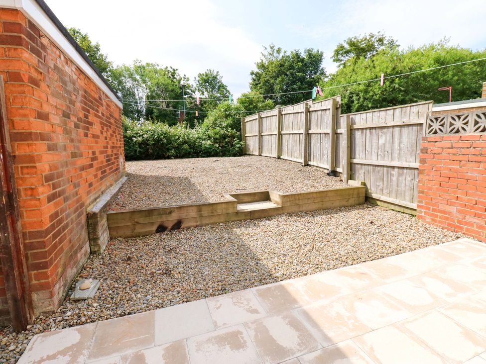 A garden with gravel and wooden retaining wall at 8 Shearwater Way Blyth