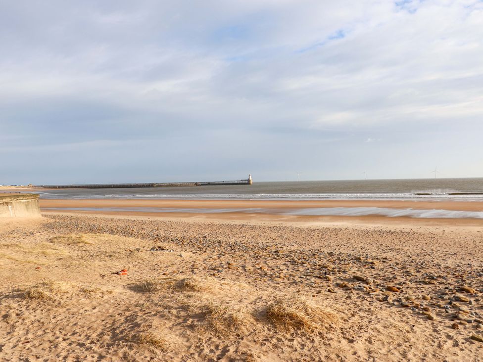 A beach with sand and a pier at 8 Shearwater Way Blyth