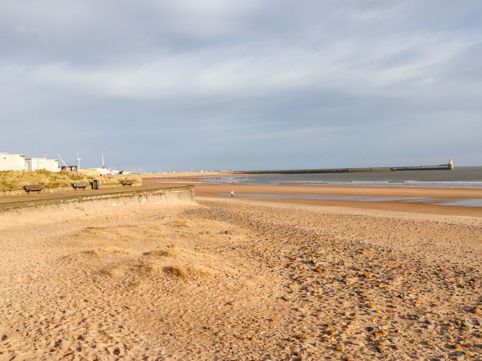 A beach with sand and a pier at 8 Shearwater Way Blyth