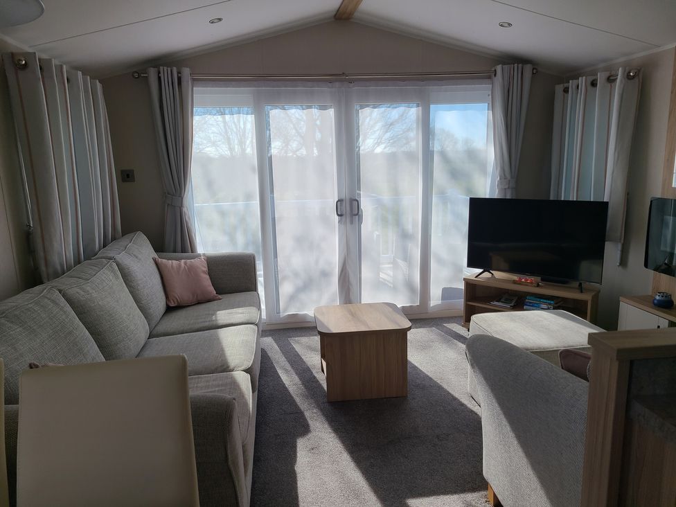 A living room with a sofa and television at The Maples, no. 56 St. Austell