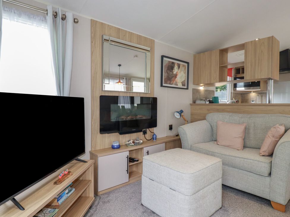 A living room with a television and sofa at The Maples, no. 56 Hewas Water near Polgooth