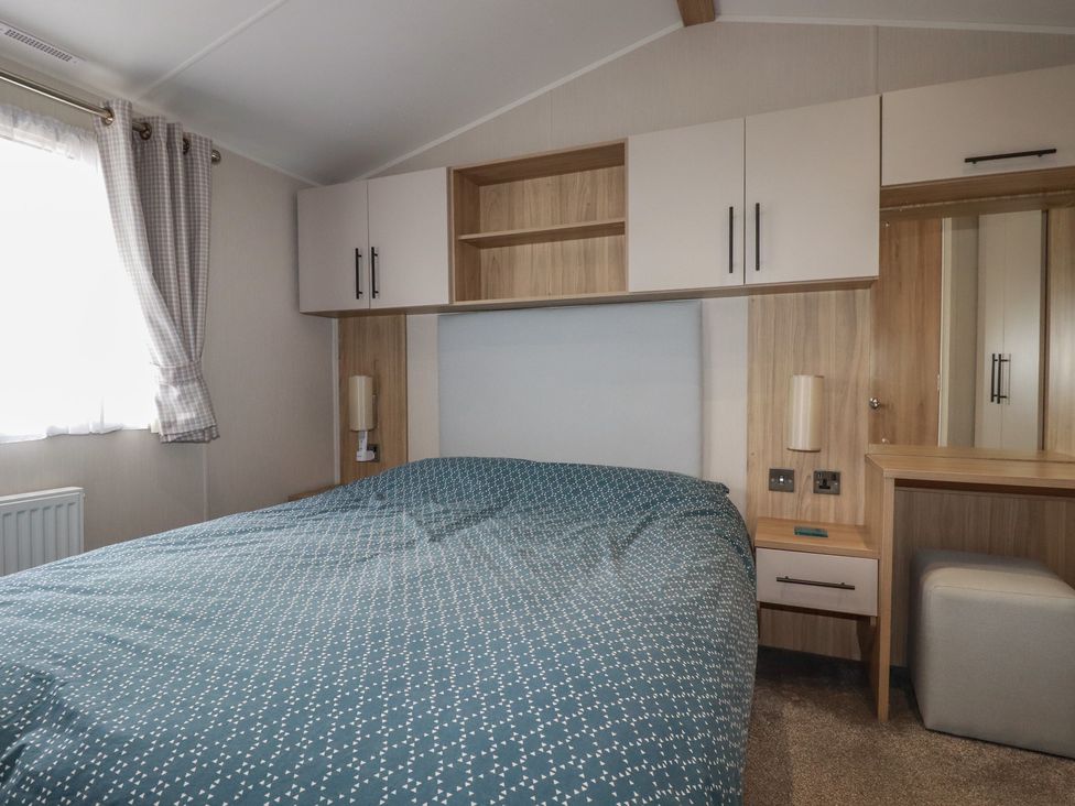 A bedroom with a bed and wardrobe at The Maples, no. 56 Hewas Water near Polgooth