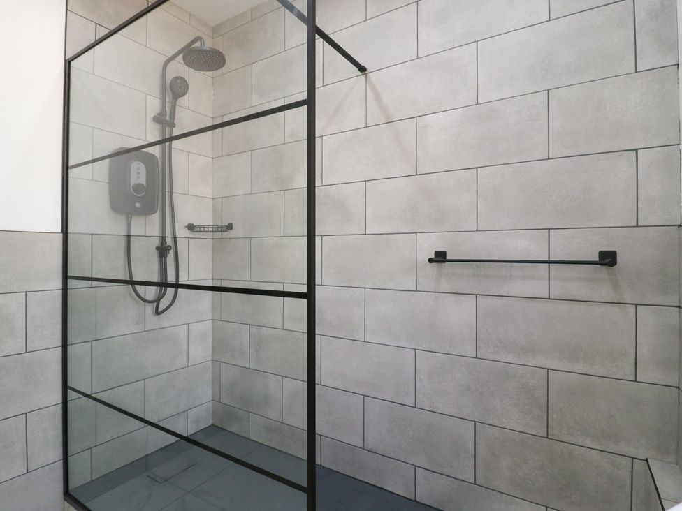 A shower enclosure with tile walls and a shower head at Annex studio 2 Northampton