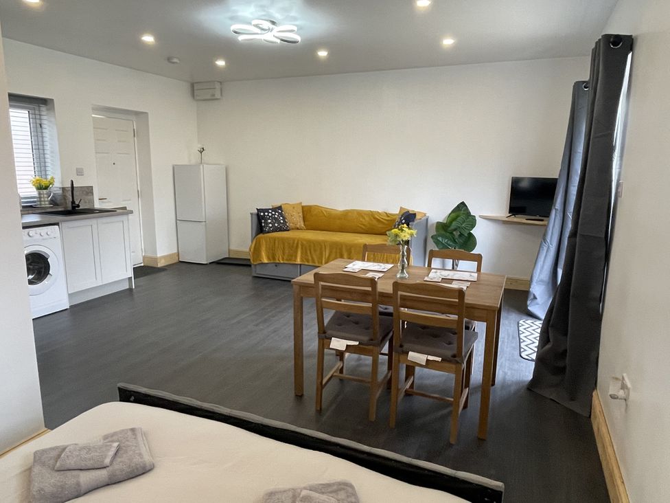 A living room with a dining table and sofa at Daffodil in Northampton