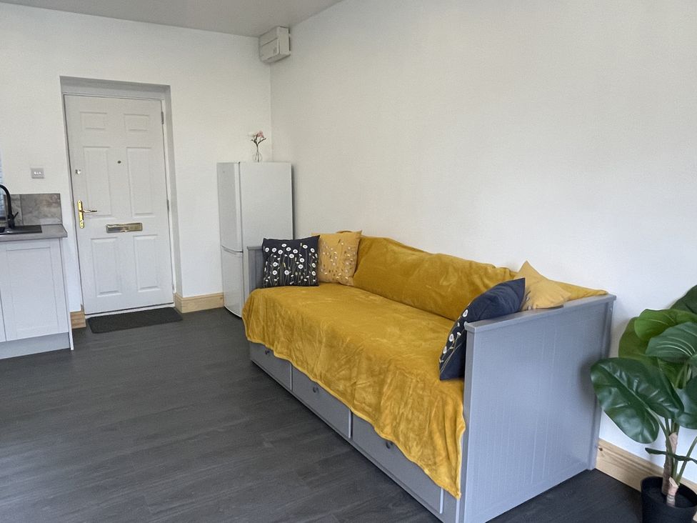 A living room with a sofa and refrigerator at Daffodil Northampton