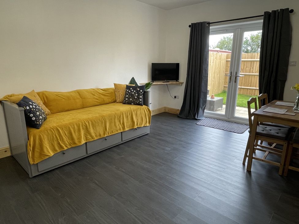 A living room with a sofa and dining area at Daffodil in Northampton