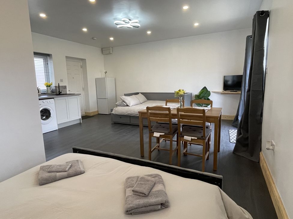 A studio with bed, dining table and television at Daffodil in Northampton