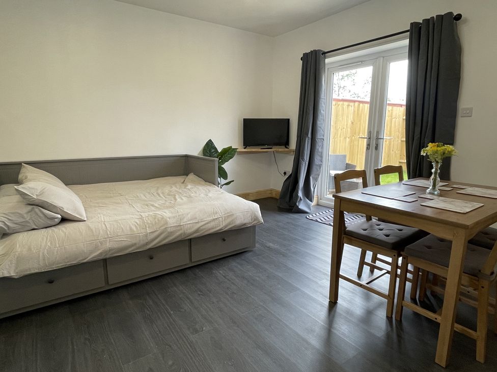 A living room with a bed and dining table at Daffodil Northampton