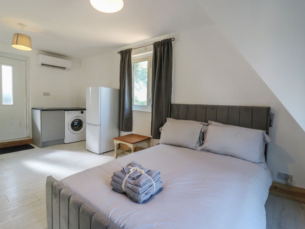 A bedroom with a bed and kitchenette area at Sunflower Northampton