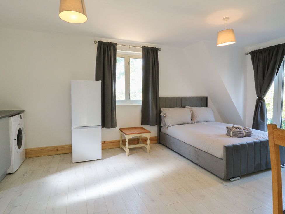 A bedroom with a bed, table and fridge at Sunflower in Northampton