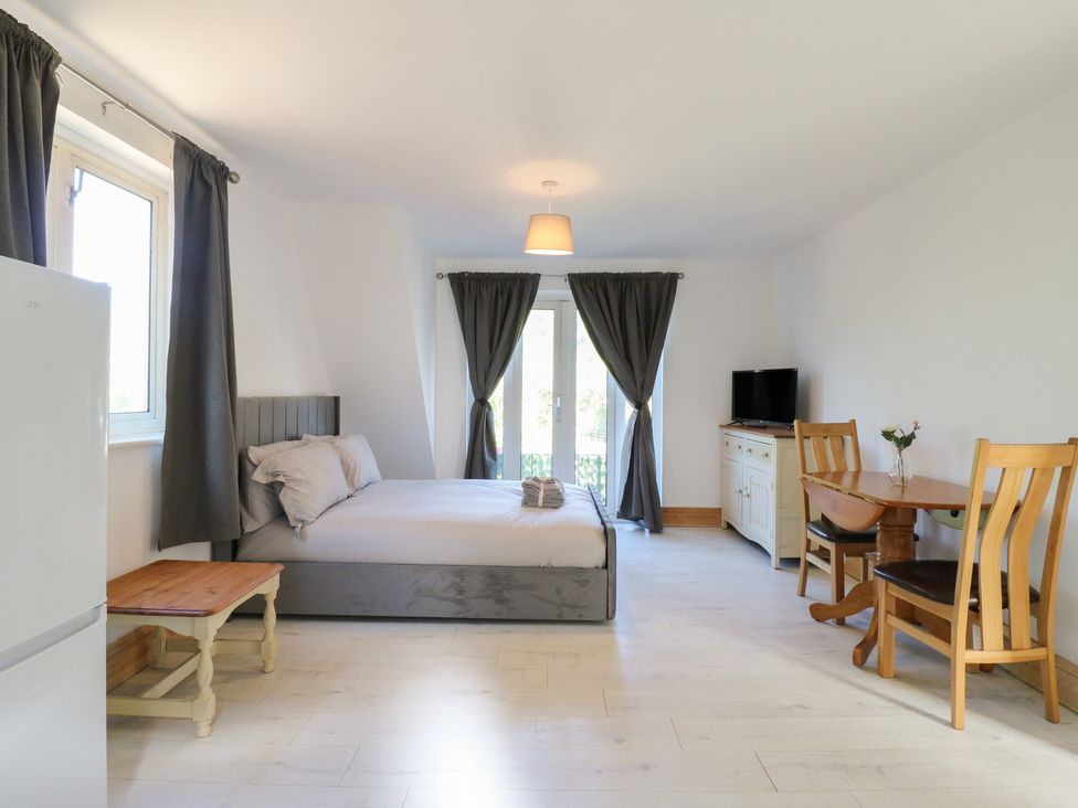 A studio with a bed, seating area and kitchenette at Sunflower Northampton