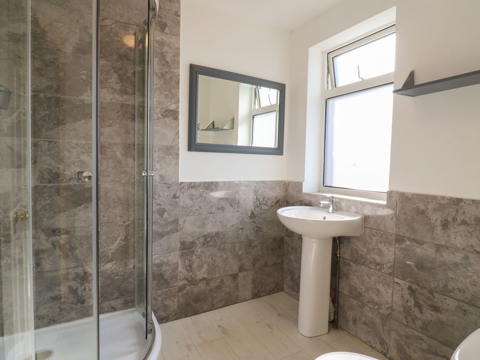 A bathroom featuring a shower, sink, mirror, and window at Sunflower in Northampton
