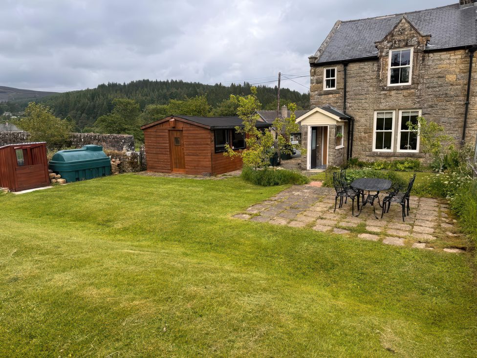 A garden with a seating area and shed at Old Station Cottage in Hexham