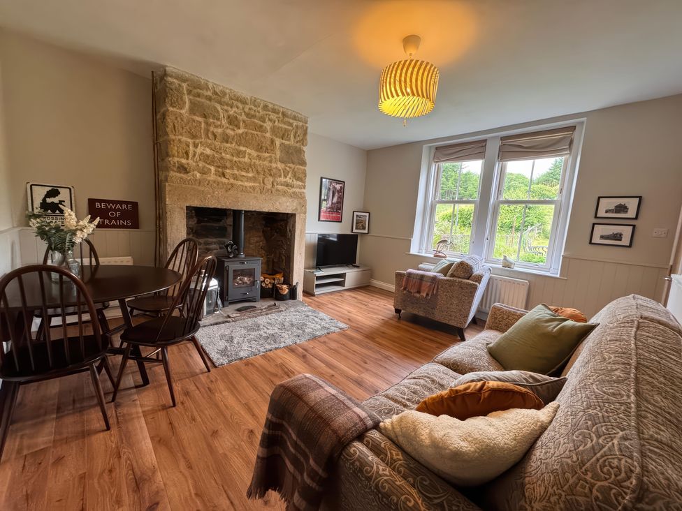 A living room with a fireplace and seating area at Old Station Cottage in Hexham