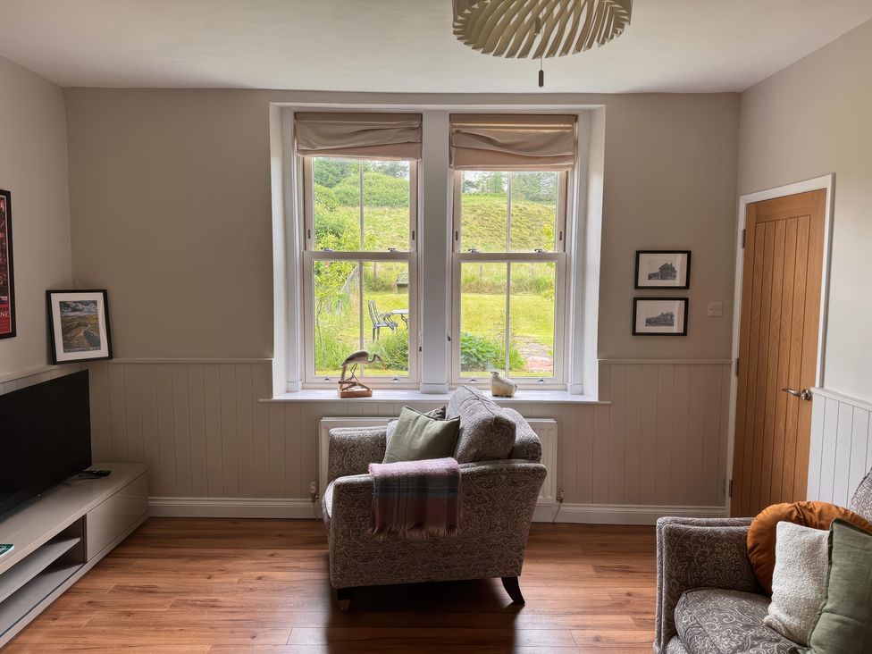 A living room featuring a sofa and television at Old Station Cottage in Hexham