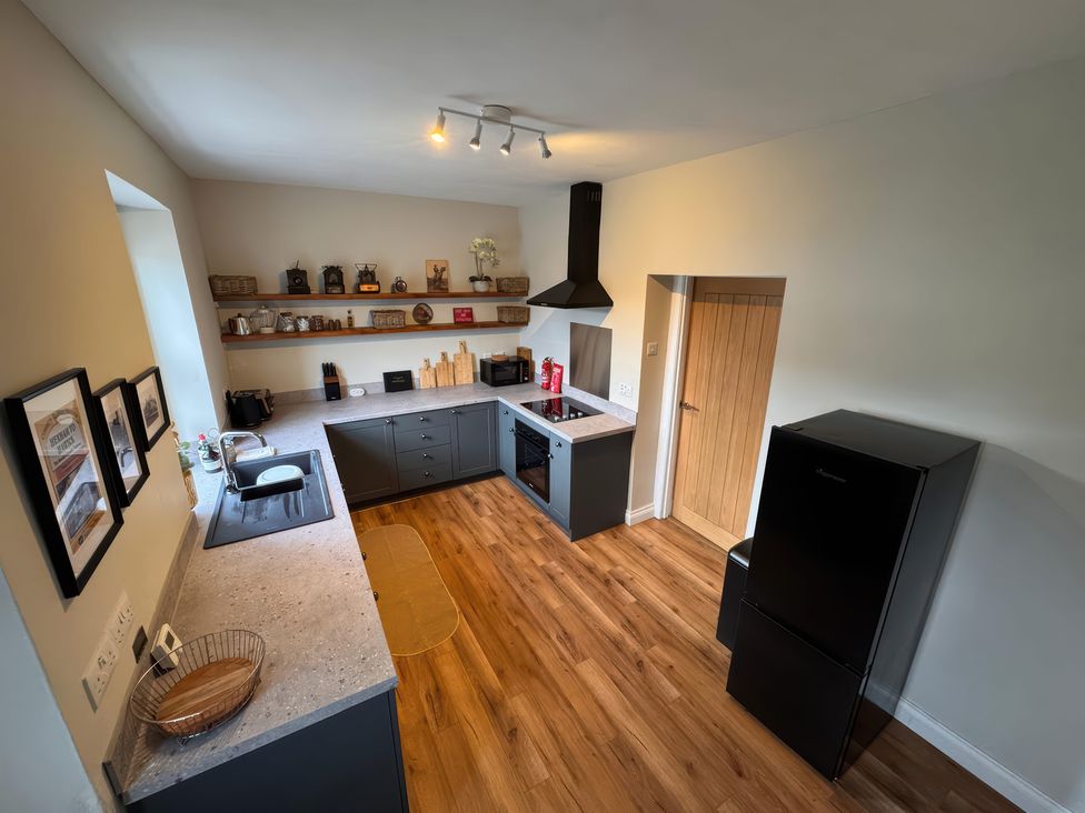 A kitchen with a stove and refrigerator at Old Station Cottage in Hexham