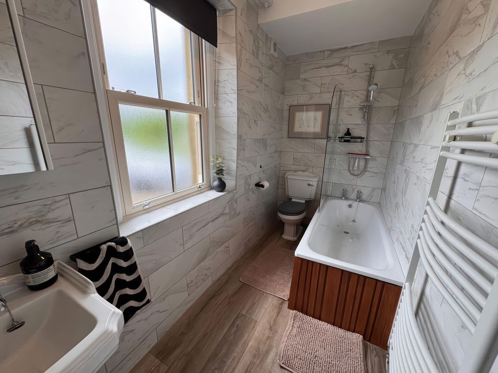 A bathroom featuring a bathtub and toilet at Old Station Cottage in Hexham