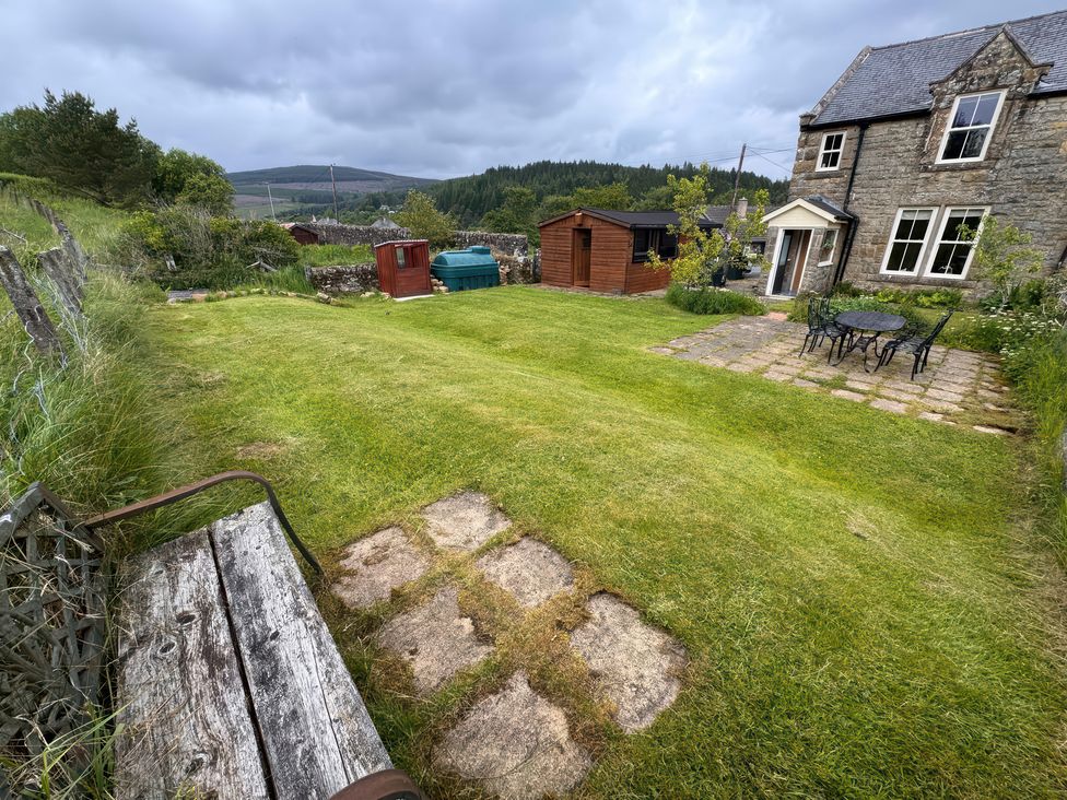 A garden with grass, a table and chairs at Old Station Cottage in Hexham