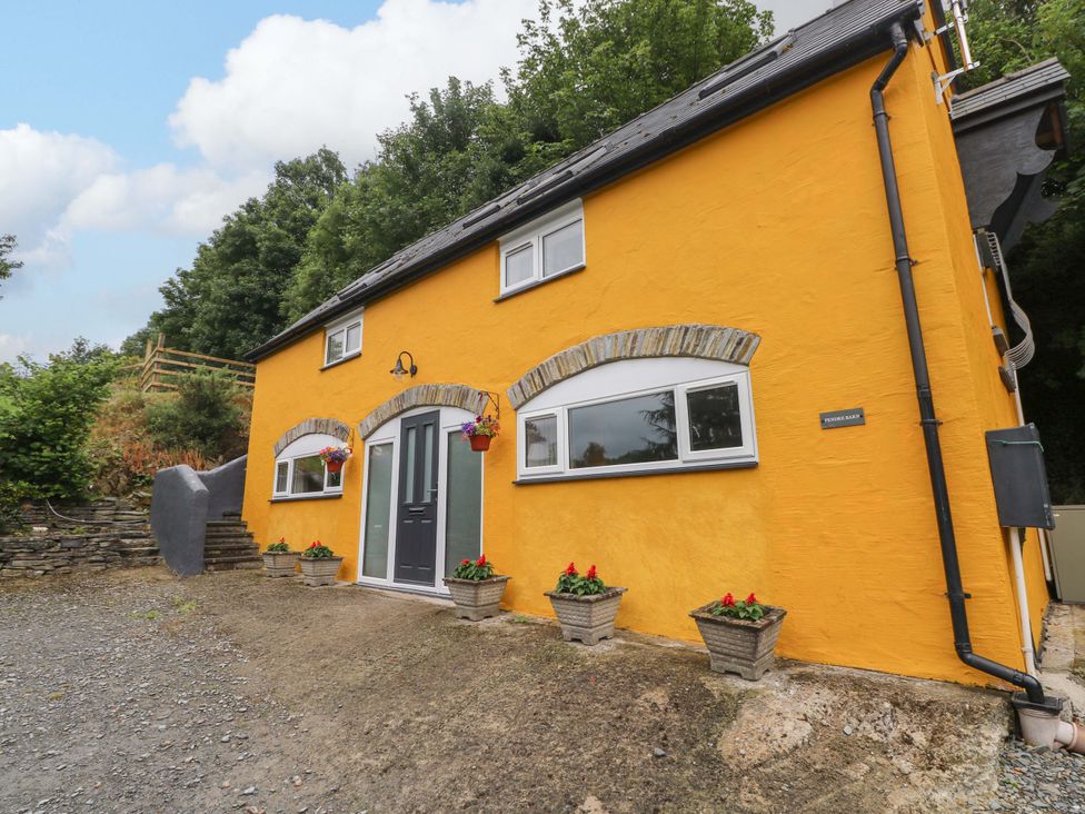 A yellow house with a door and windows at Pendre Barn Llanfyrnach