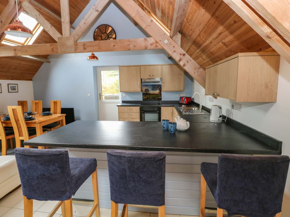 A kitchen with a dining table and counters at Pendre Barn in Llanfyrnach
