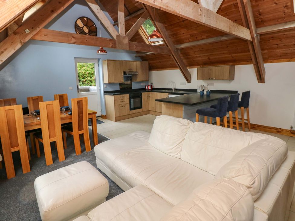 A living room with a sofa and dining area at Pendre Barn Llanfyrnach