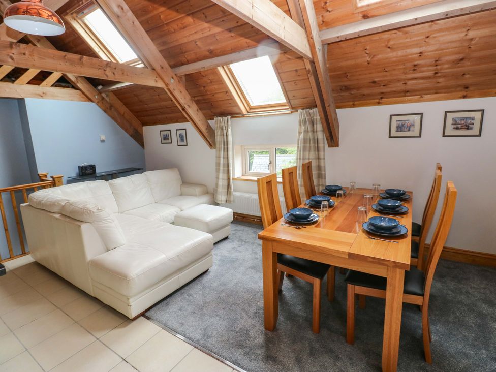 A living room with a dining area and sofa at Pendre Barn Llanfyrnach