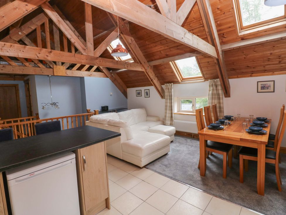 A living room with a sofa and dining area at Pendre Barn Llanfyrnach
