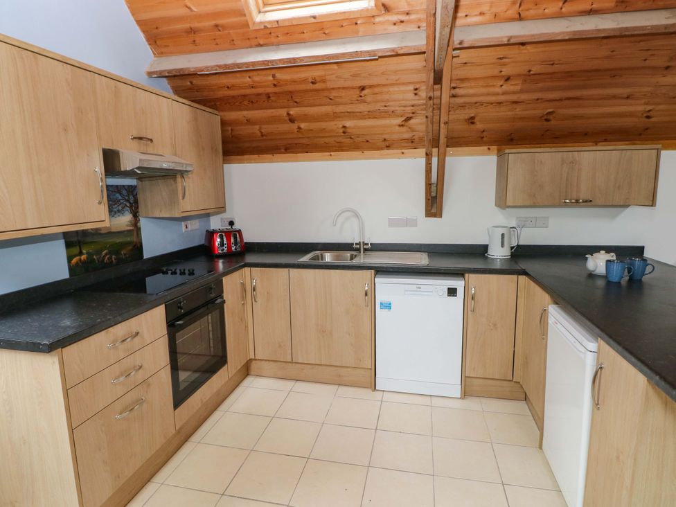 A kitchen with cabinets and appliances at Pendre Barn Llanfyrnach