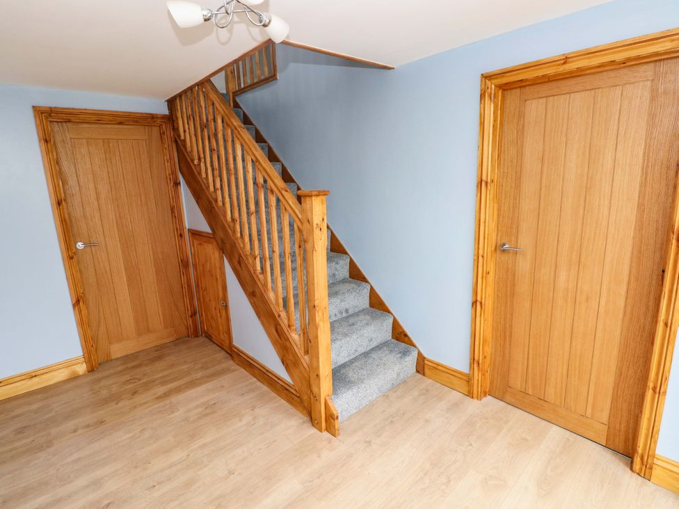 A hallway with a staircase and doors at Pendre Barn in Llanfyrnach
