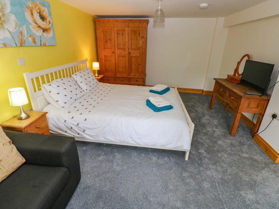 A bedroom with a bed and wardrobe at Pendre Barn in Llanfyrnach