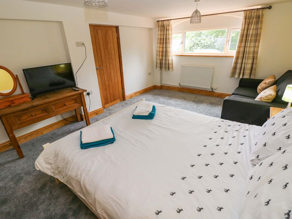 A bedroom with a bed and a television at Pendre Barn Llanfyrnach