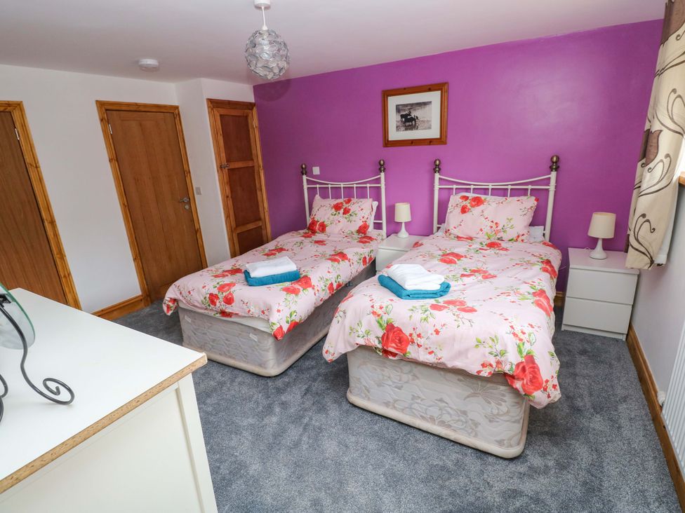 A bedroom with two single beds and a bedside table at Pendre Barn Llanfyrnach