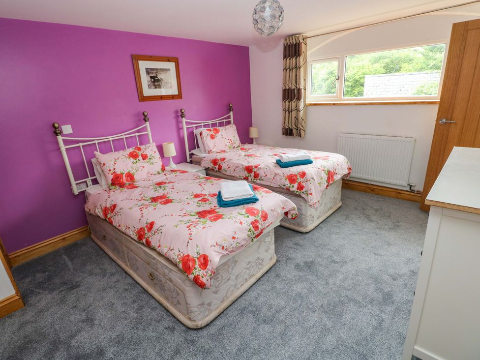 A bedroom with twin beds and a window at Pendre Barn in Llanfyrnach
