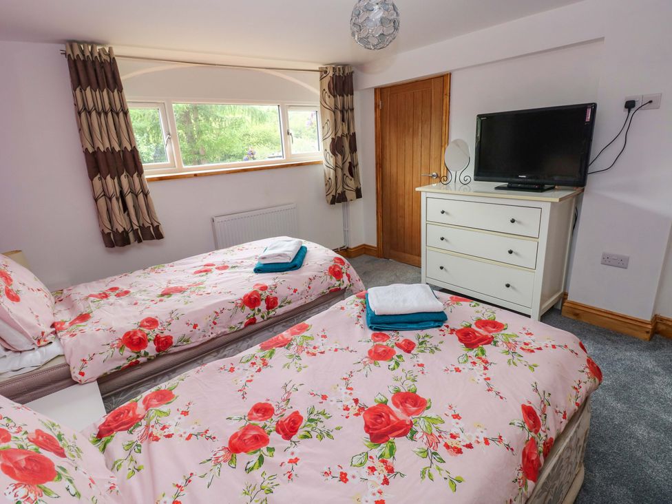 A bedroom with two beds and a television at Pendre Barn Llanfyrnach