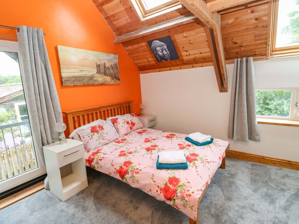 A bedroom with a bed and nightstands at Pendre Barn in Llanfyrnach